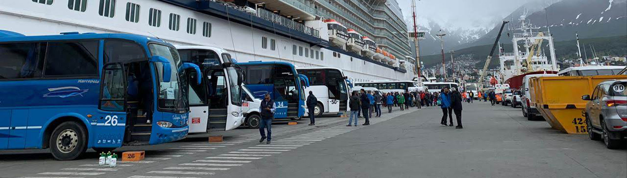 Large buses parked by a port.