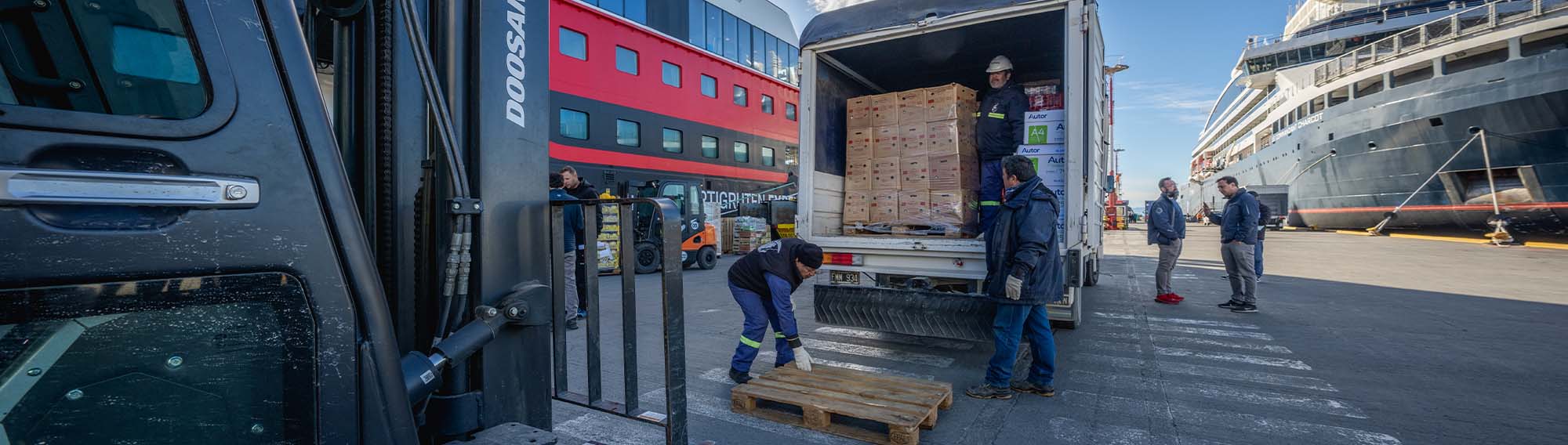 Delver Agents moving cargo from truck to fork lift.