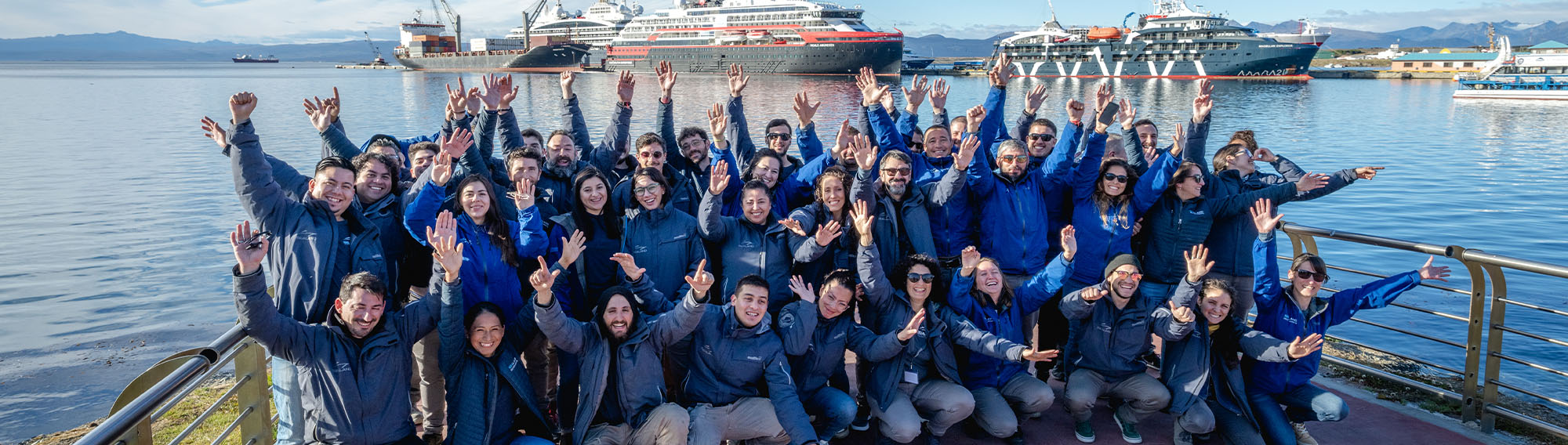 Delver Agents waving happily in a group team photo.