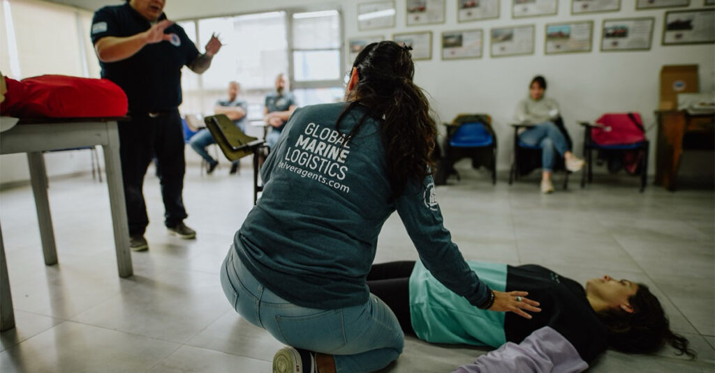 A Delver Agents employee practicing CPR with another person, while being instructed by the instructor.