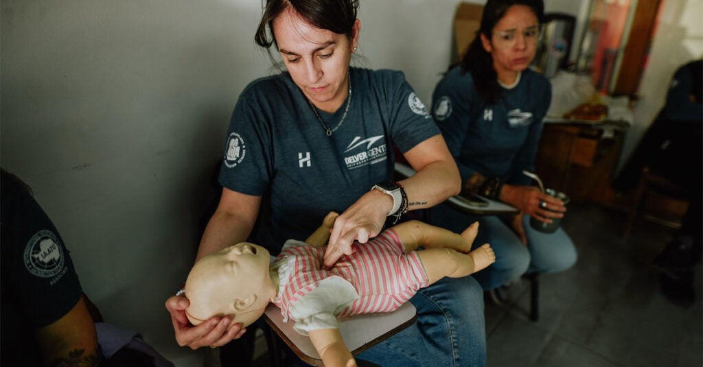 A Delver Agents employee practicing CPR on a dummy doll.