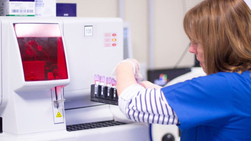 A tech handling lab vials